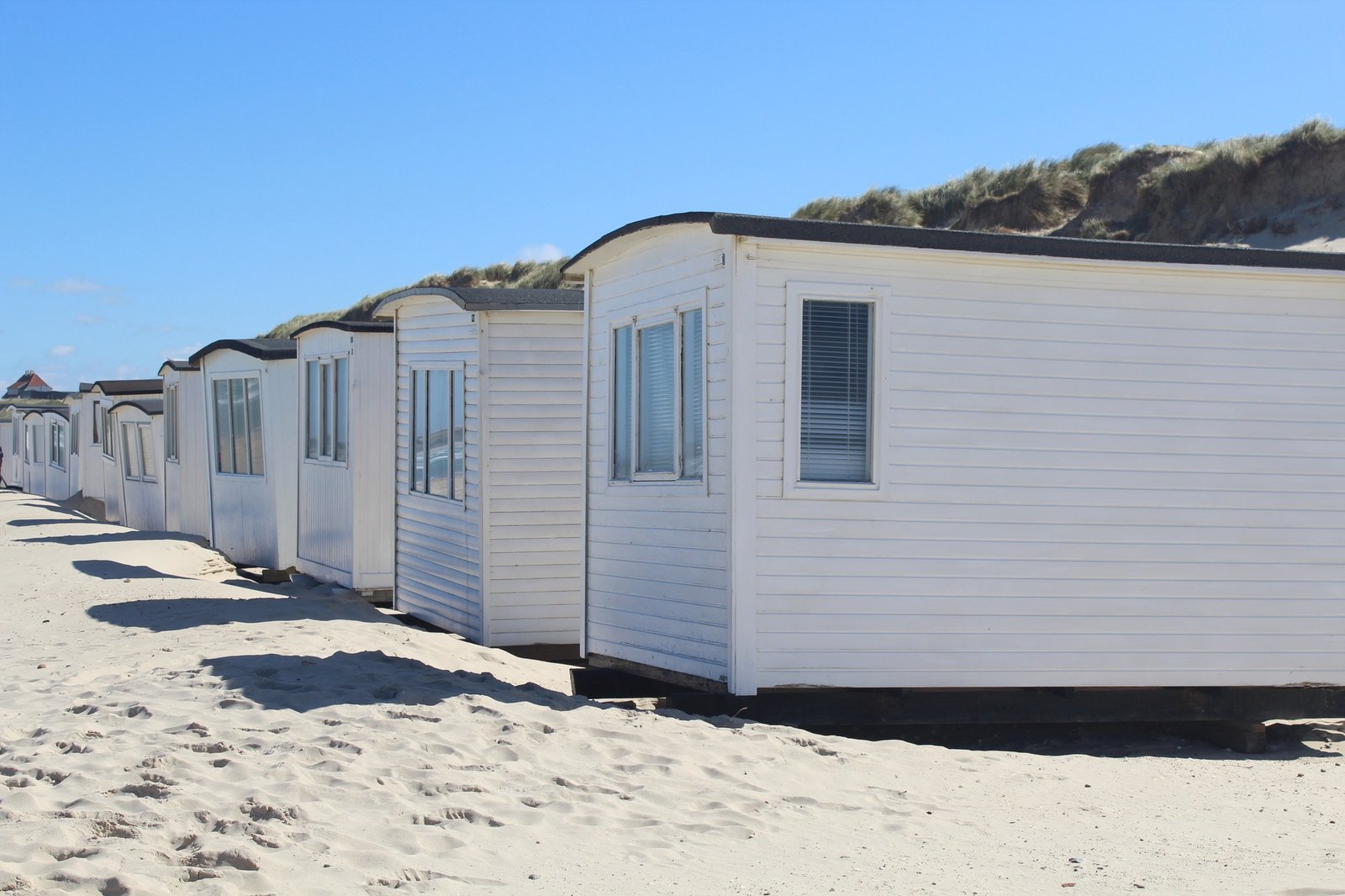 Reihe weißer Mobilheime am Strand
